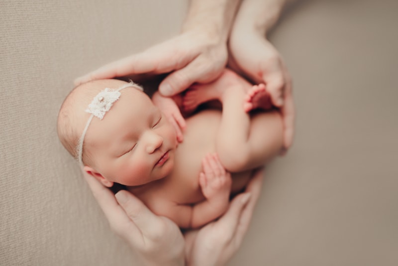Wellsville NY Family & Newborn Photographer, baby girl sleeping between parents' hands