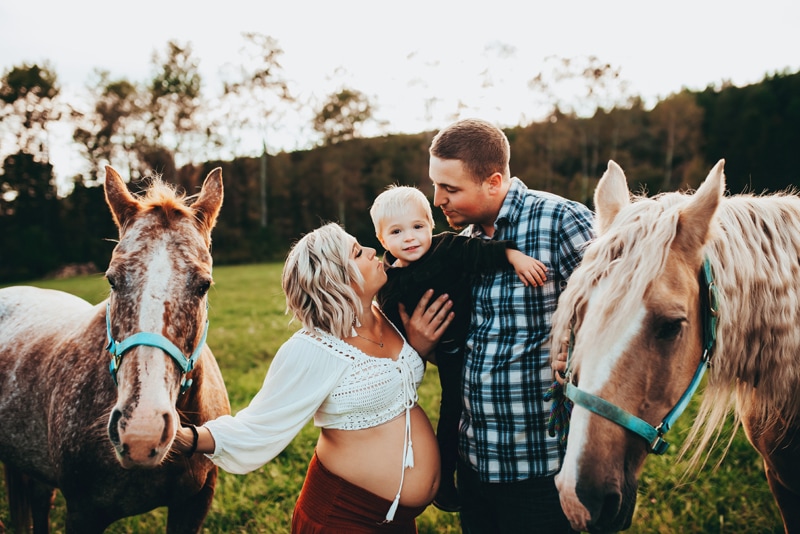 Wellsville NY Family & Newborn Photographer, family of three standing next to two horses
