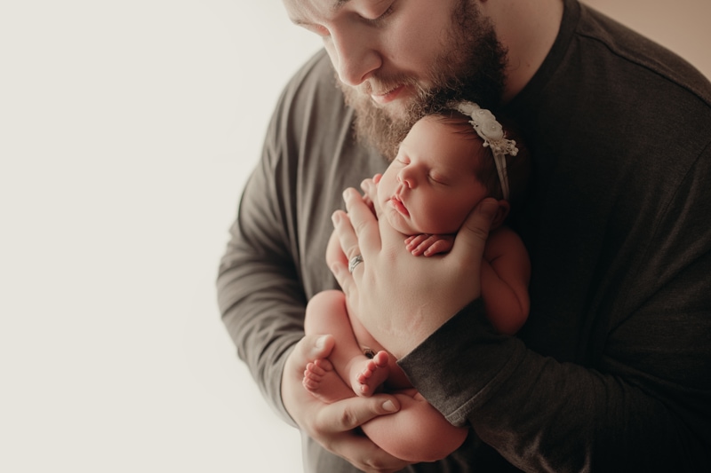Wellsville NY Family and Newborn Photographer, father holding baby girl up on his chest
