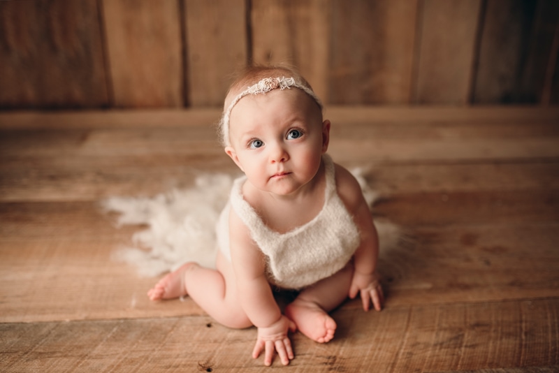 Wellsville NY Family and Newborn Photographer, baby girl on a wood bkg