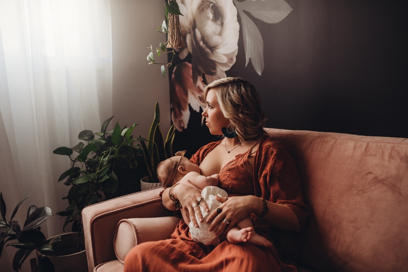 Wellsville NY Family and Newborn Photographer, mother looking out window while breastfeeding